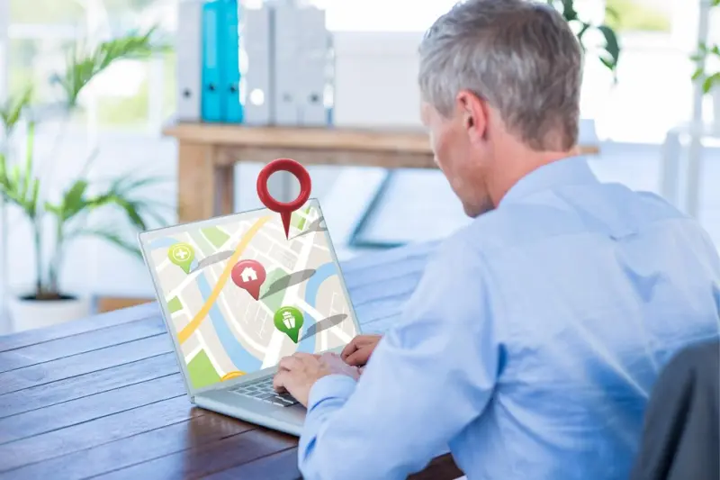 Map Search On Laptop Businessman using laptop displaying map with location pins Business directory